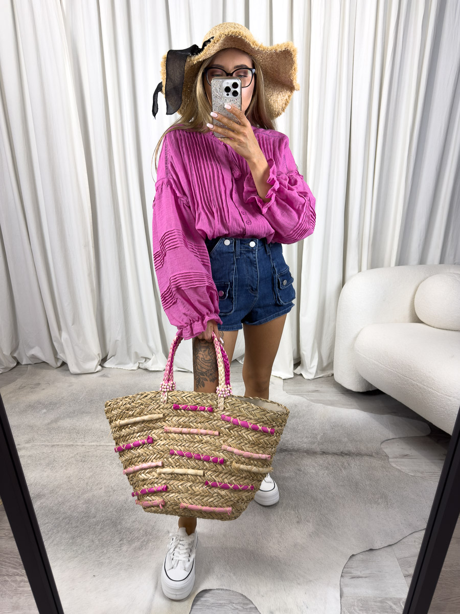 Zdjęcie produktowe sklepu internetowego z odzieżą damską – modelka ubrana w koszule Boho w kolorze fuksji marki Wiya, jeansowe szorty oraz dodatki typu słomiany kapelusz, wiklinowa torebka koszyk