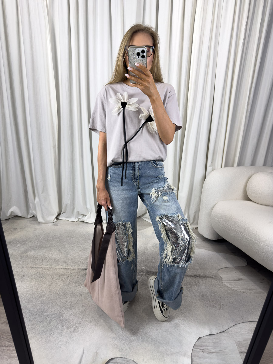 Zdjęcie produktowe sklepu internetowego z odzieżą damską – modelka ubrana w t-shirt Flower 3D beżowy i luźne jeansy oraz zamszową torebkę