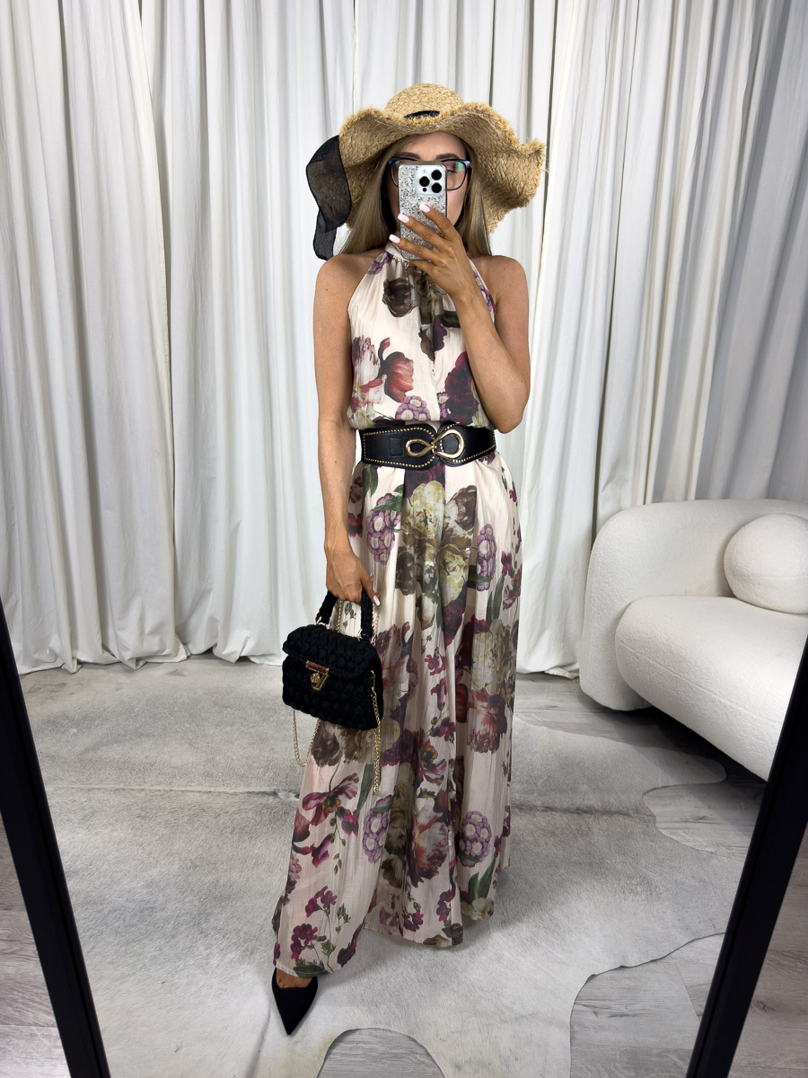 Kombinezon Maxi Venice z długimi, szerokimi nogawkami i zabudowanym dekoltem halter, kobieta w kapeluszu trzyma czarną torebkę na łańcuszku. Zdjęcie produktowe sklepu internetowego z odzieżą damską.