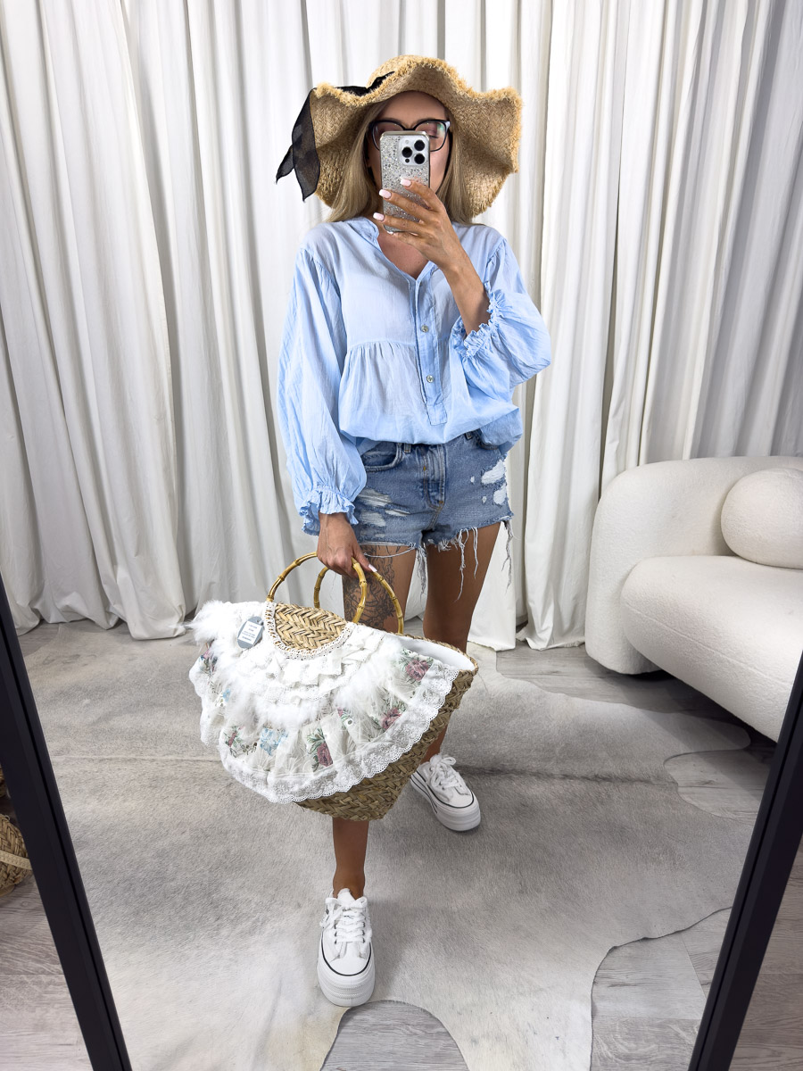 Zdjęcie produktowe sklepu internetowego z odzieżą damską – modelka w lekkiej koszuli Sand, jeansowych szortach, z kapeluszem.