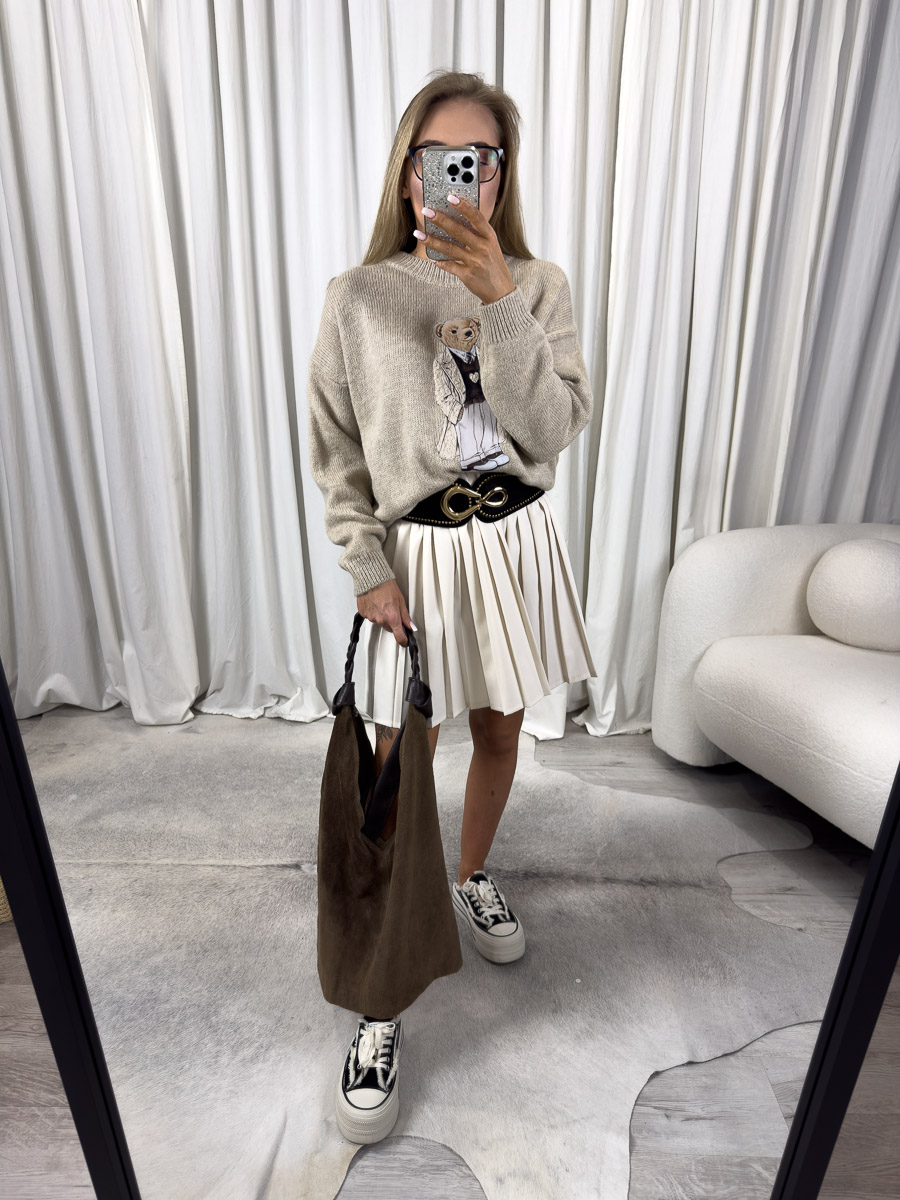 Zdjęcie produktowe sklepu internetowego z odzieżą damską – modelka w trampkach ubrana w sweter Teddy beżowy, krótką plisowaną spódnicę
