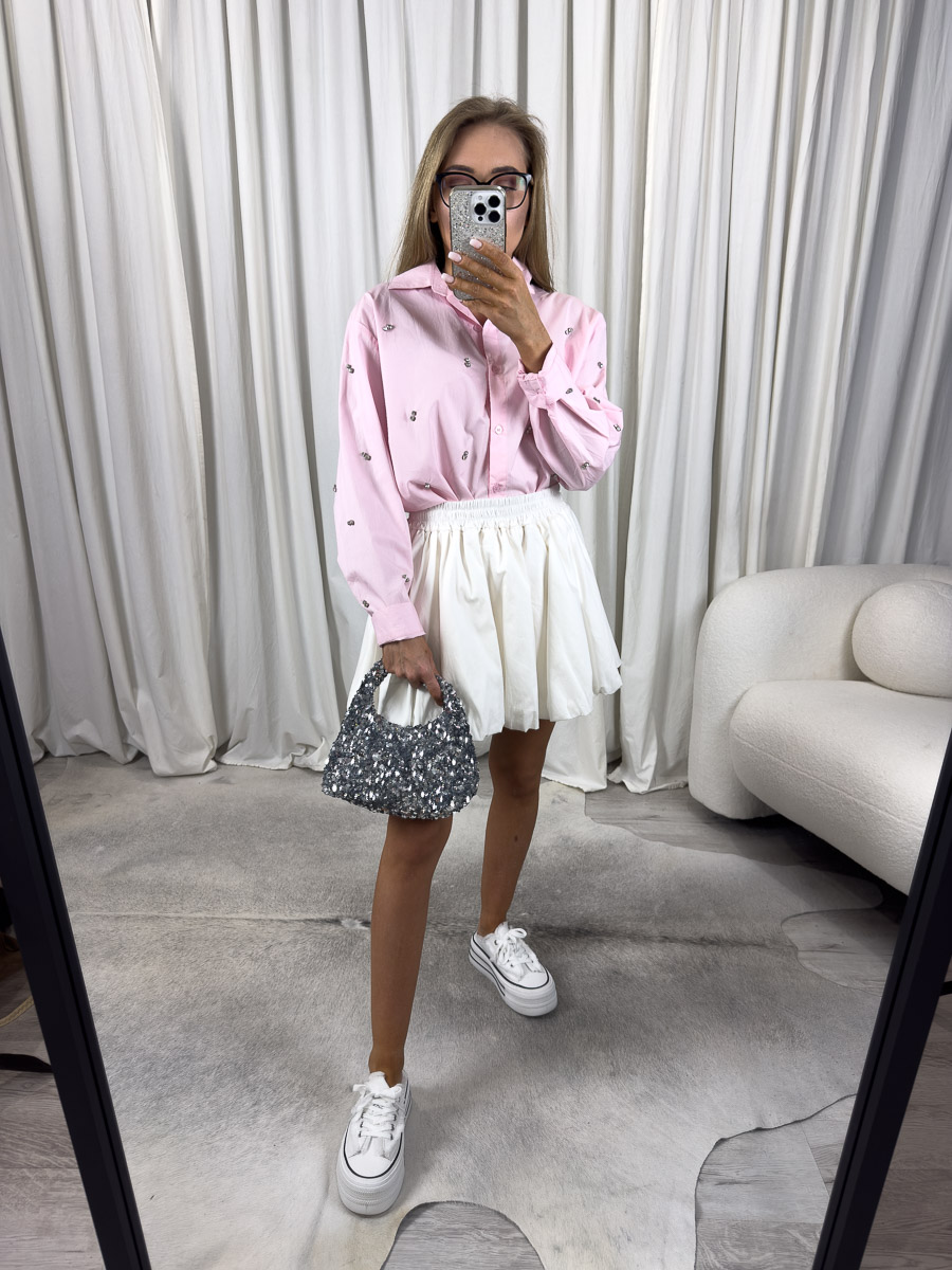 Zdjęcie produktowe sklepu internetowego z odzieżą damską – modelka ubrana w koszule popelinową Viven w kolorze pudrowego różu, spódnico-spodenki w kolorze białym oraz białe trampki