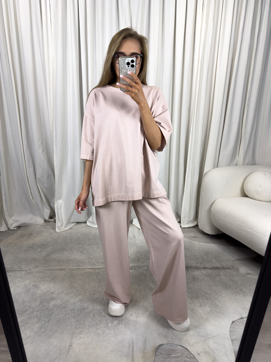 Komplet dresowy Loose Wiya jasny róż – kobieta w jasnoróżowym komplecie dresowym oversize marki Wiya, stylizacja casualowa z szerokimi spodniami i luźną bluzą.