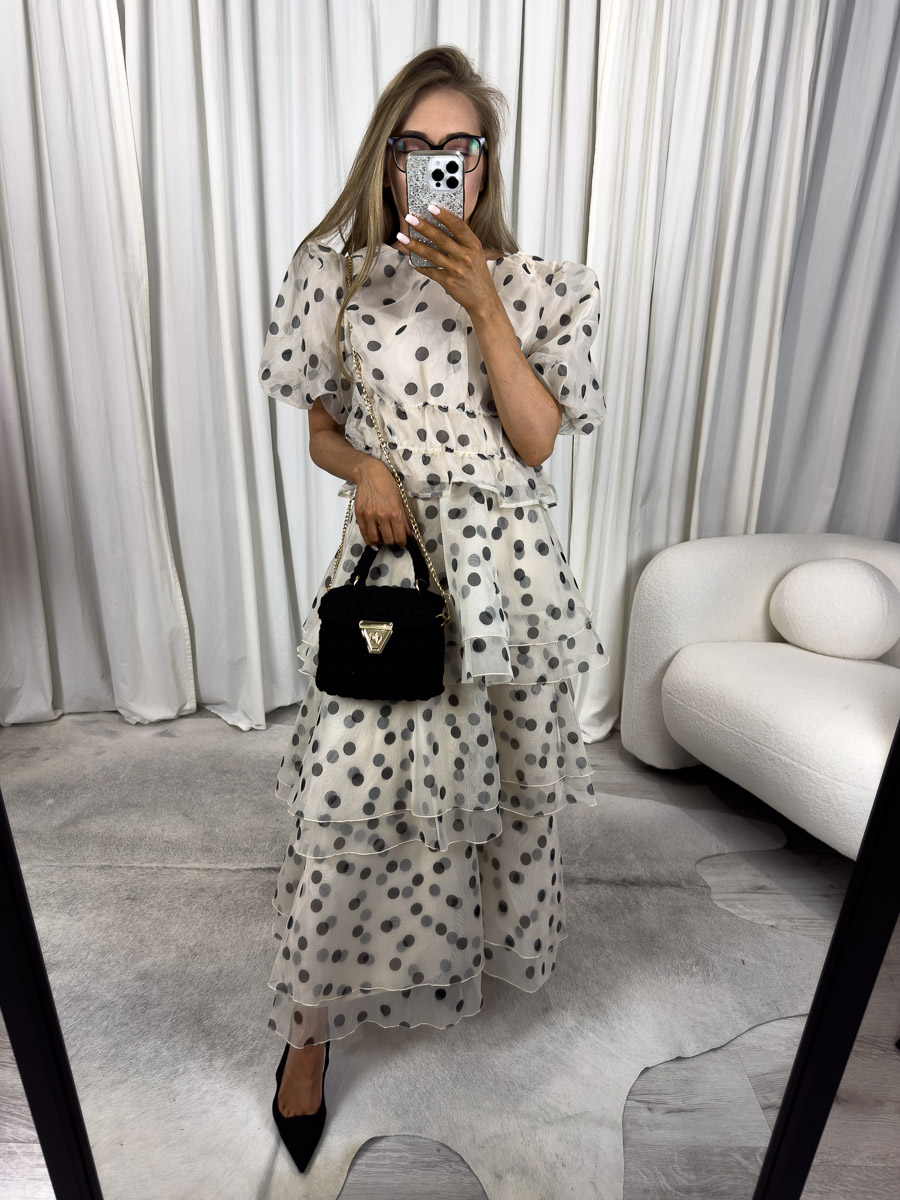 Modelka w komplecie w grochy Sole – zestaw z bufiastego topu i warstwowej spódnicy midi, stylizacja z czarną torebką i szpilkami – zdjęcie produktowe do sklepu odzieżowego online.